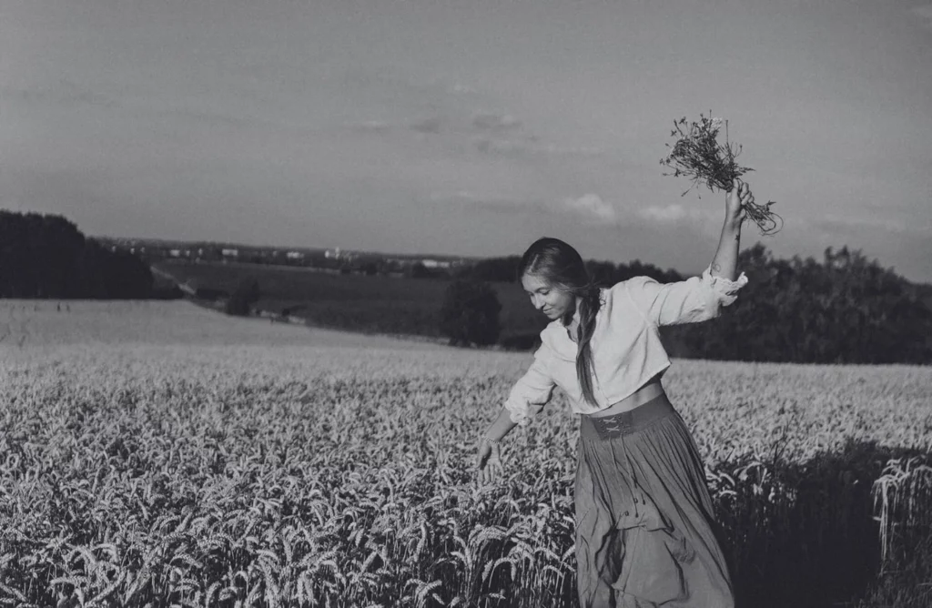 Femme dans un champ tenant des fleurs dans sa main